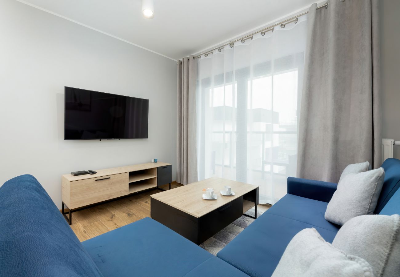 salon, jadalnia, stół, krzesła, sofa, stolik kawowy, telewizor, aneks kuchenny, apartament, wnętrze, wynajem